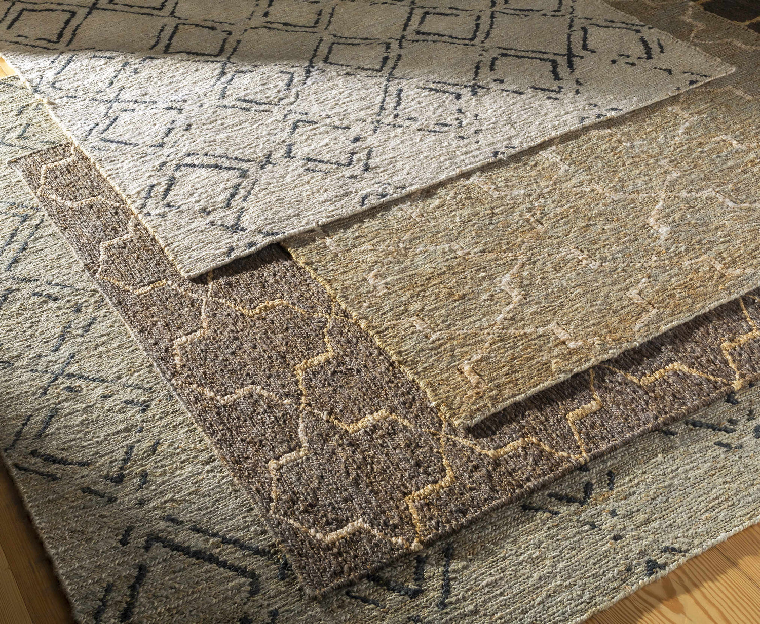 Close-up of Monkstown Jute Carpet showing hand-woven texture and geometric patterns in black, taupe, and gray. Clearance item. Styleshot