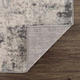 Close-up of the Kalanganan Abstract Gray Rug showing its charcoal, gray, and off-white pattern and woven backing. Fold