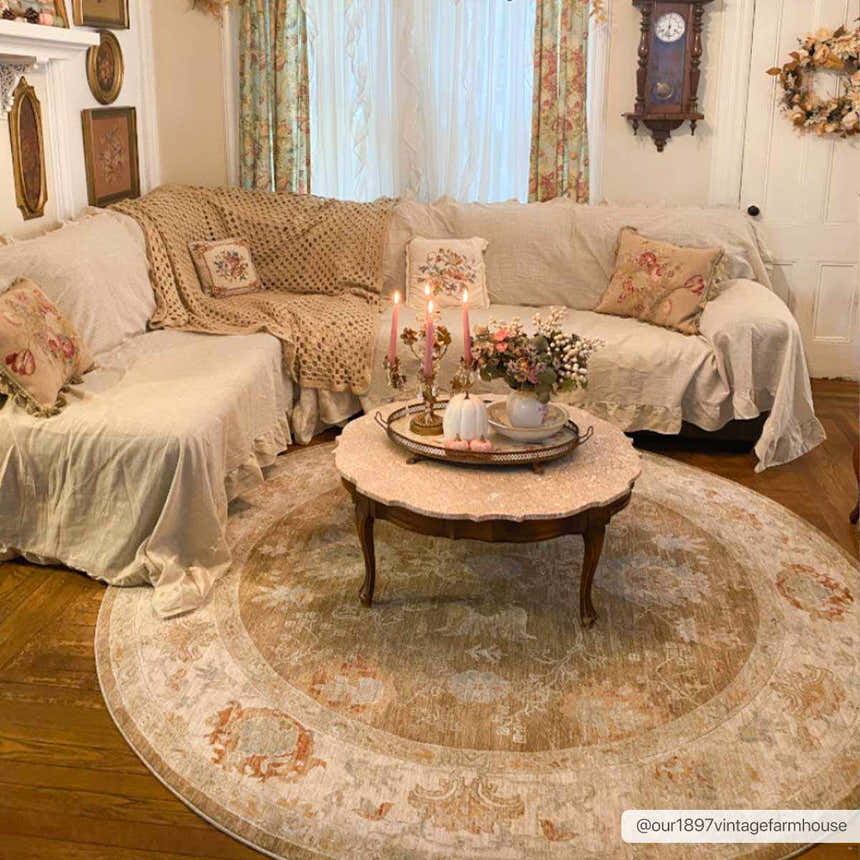 Farmhouse living room with a round Rangeville Luxe Statement Rug in brown, orange, and cream under a coffee table. Roomscene-Round