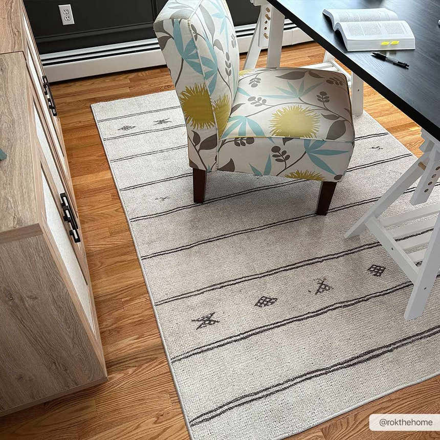Home office with Rivi Moroccan Beige rug, floral chair, wood floors, and black desk. Roomscene-Rectangle