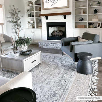 Living room with fireplace and Rudo Beige rug. Farmhouse style with gray armchairs and white built-in shelves. Roomscene-Rectangle