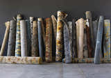 Rolled rugs on display, including a Sage Brown Elsu Area Rug with floral pattern. Styleshot