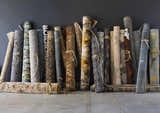 Rolled rugs in various colors and patterns, including a floral Sage Brown Elsu Area Rug. Styleshot