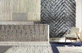 Close-up of Plean Premium Rugs in charcoal, cream, denim, and gray, showcasing hand-knotted texture and fringe. Styleshot