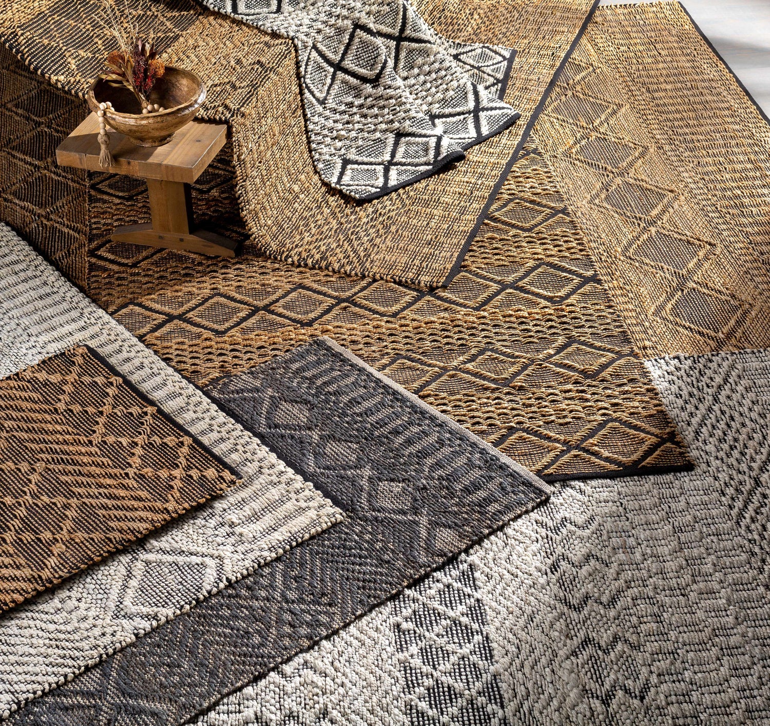 Close-up of geometric Nasugbu Jute Carpet in black, tan, and gray. Hand-woven jute texture, bohemian farmhouse style. Styleshot