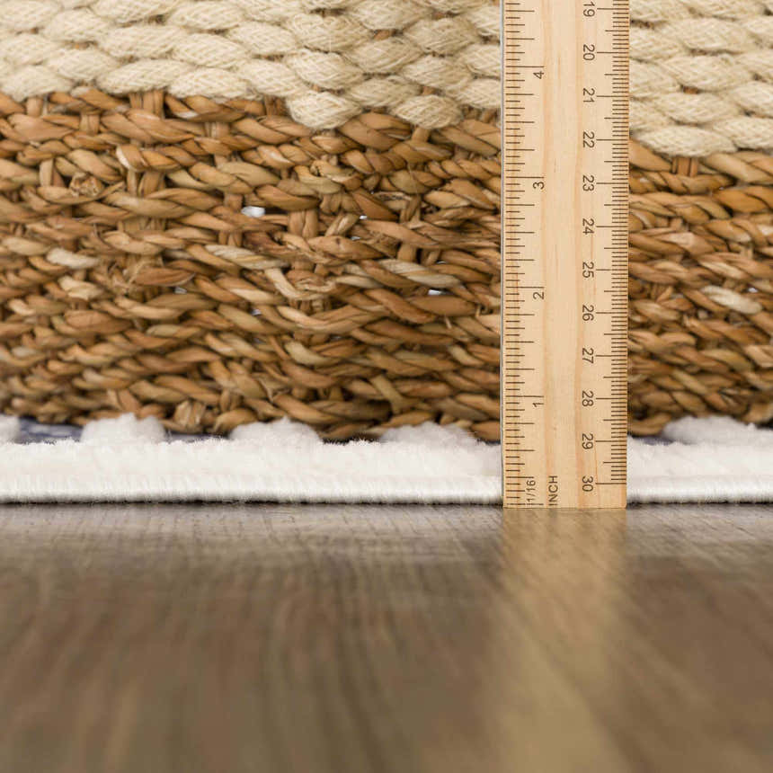 Close-up of the Anah Blue Outdoor Rug showing the rug's pile height and texture with a ruler for scale. Pile