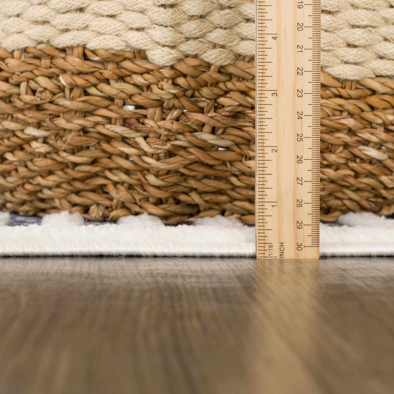 Close-up of the Anah Blue Outdoor Rug showing the rug's pile height and texture with a ruler for scale. Pile