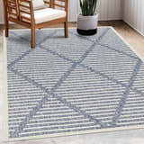 Outdoor patio scene with wood chair and potted plant on the Anah Blue Outdoor Rug. Roomscene-Rectangle
