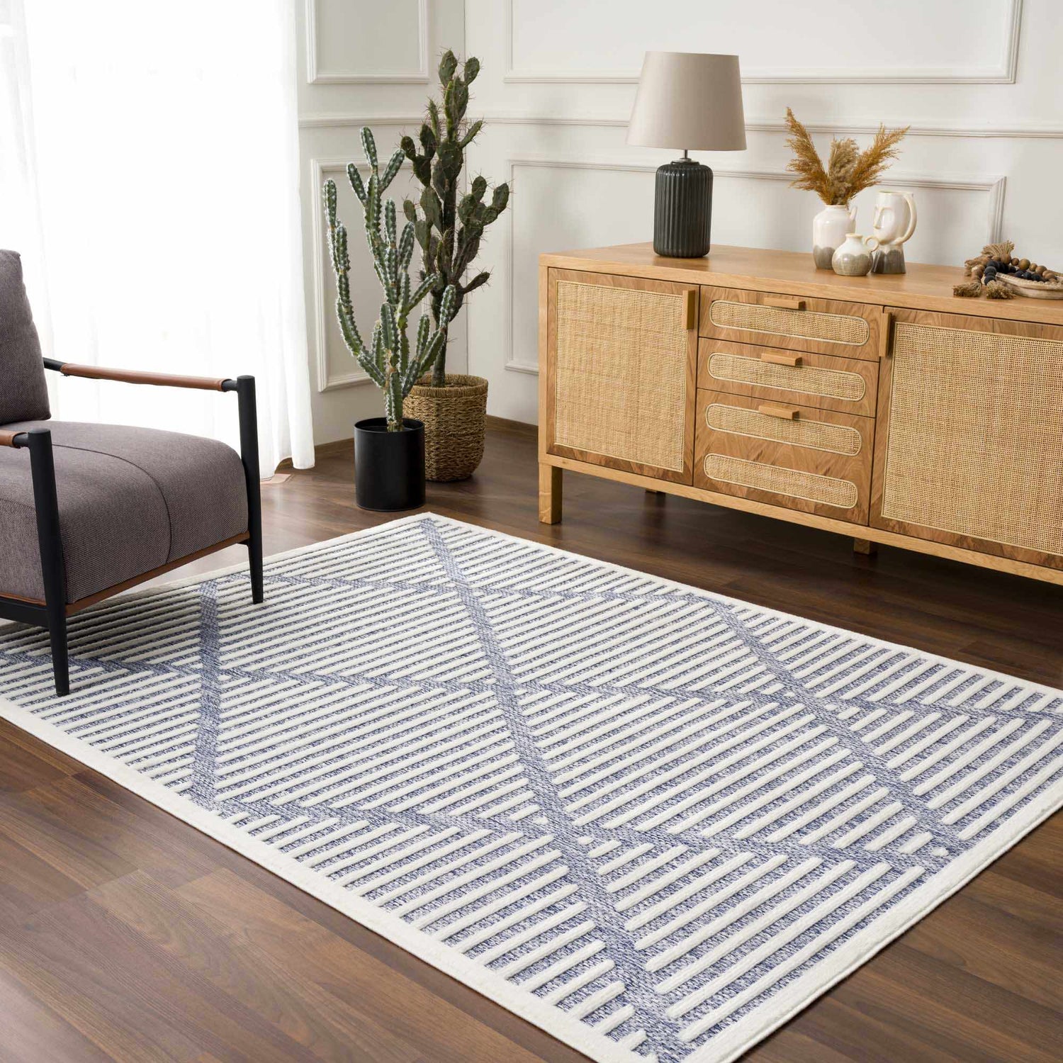 Living room scene with Anah Blue Outdoor Rug, gray chair, and wooden cabinet. Contemporary style. Roomscene-Rectangle