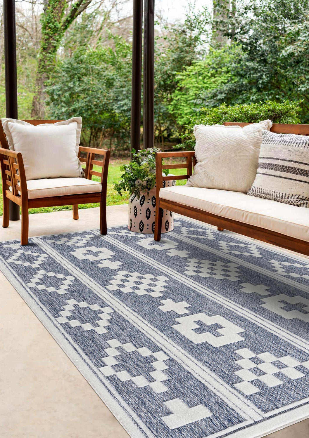 Outdoor patio scene with wood furniture and blue and white Hiro Blue Outdoor Rug. Roomscene-Rectangle