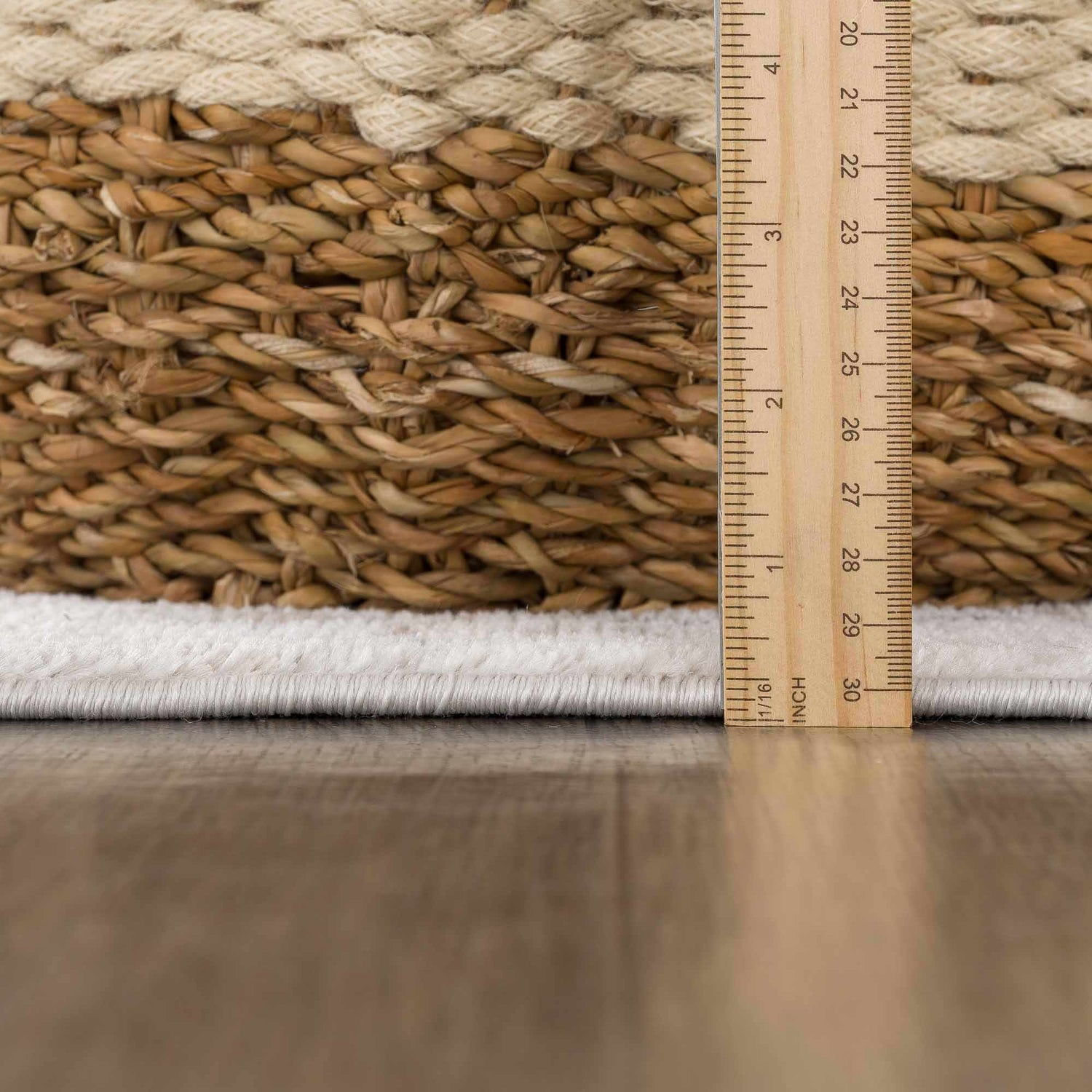 Close-up of Mudgee Area Rug showing cream pile height and tan weave texture with ruler for scale. Pile