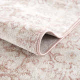 Close-up of the Snead Pink Floral Rug showing light beige and pale pink floral pattern and plush texture. Fold