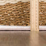 Close-up of the Snead Pink Floral Rug showing the rug's pile height with a ruler and the light beige and pale pink colors. Pile