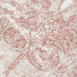 Close-up of the Snead Pink Floral Rug, showing its light beige base and pale pink floral pattern. Soft, textured weave. Texture