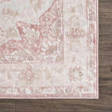 Close-up of the Kandos Blush & Light Pink Area Rug showing its cream, pale pink, and light beige traditional pattern. Corner