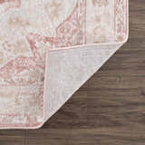 Close-up of the Kandos Blush & Light Pink Area Rug showing its cream, beige, and pink traditional pattern and woven texture. Fold