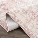 Close-up of the Kandos Blush & Light Pink Area Rug showing its traditional design, soft texture, and blush pink trim. Fold