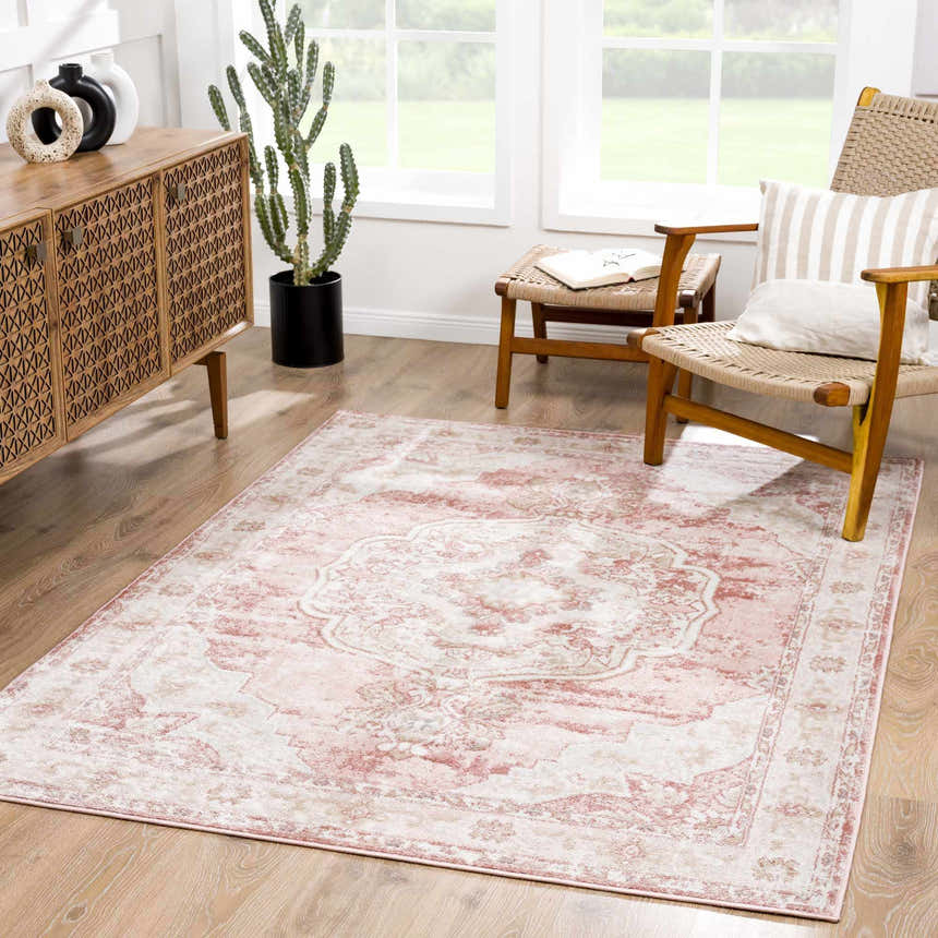 Living room scene with a Kandos Blush & Light Pink Area Rug, wood cabinet, woven chair, and natural light. Roomscene-Rectangle