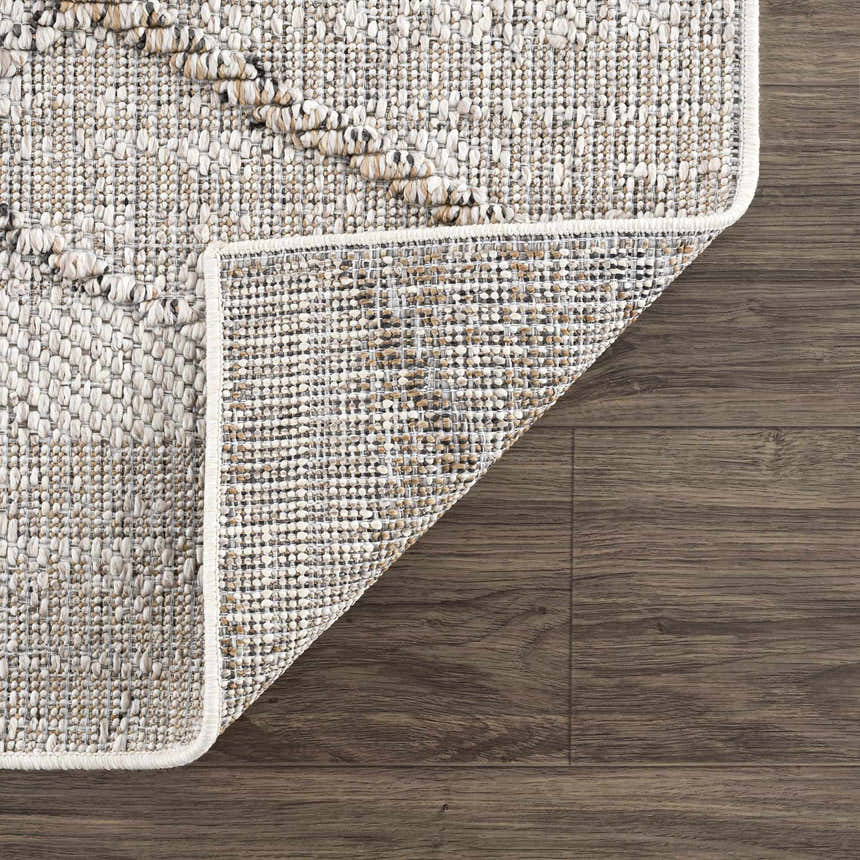 Close-up of the textured Baqer Bone & Tan Performance Rug showing its woven design and backing on a wood floor. Fold