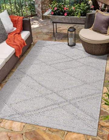 Outdoor patio scene with Baqer Taupe & Gray Textured Performance Rug, wicker furniture, and stone flooring. Roomscene-Rectangle