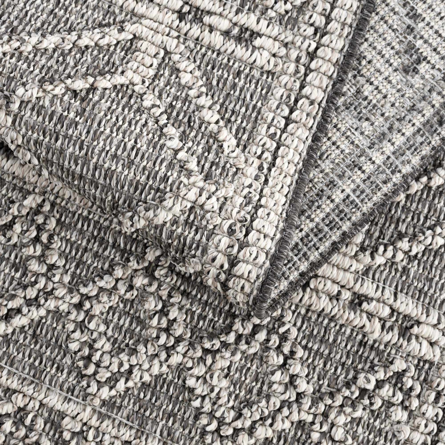 Close-up of the Diah Black & Bone Area Rug showing its textured, woven design and black and bone color palette. Fold