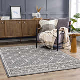 Living room scene with Diah Black & Bone Area Rug, gray chair, wood cabinet, and modern decor. Stylish and inviting. Roomscene-Rectangle