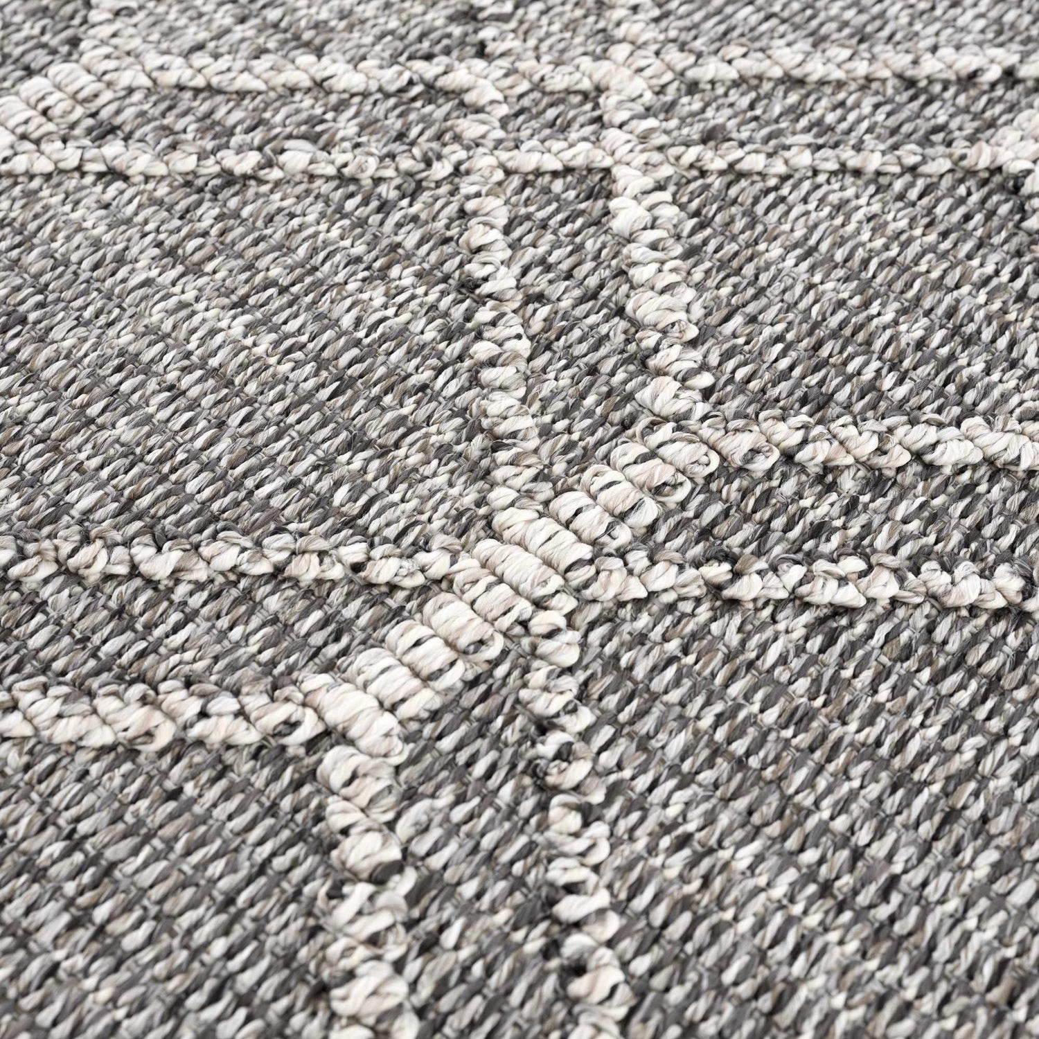 Close-up of the Diah Black & Bone Area Rug, showing its woven texture and geometric bone-colored pattern on a black base. Texture