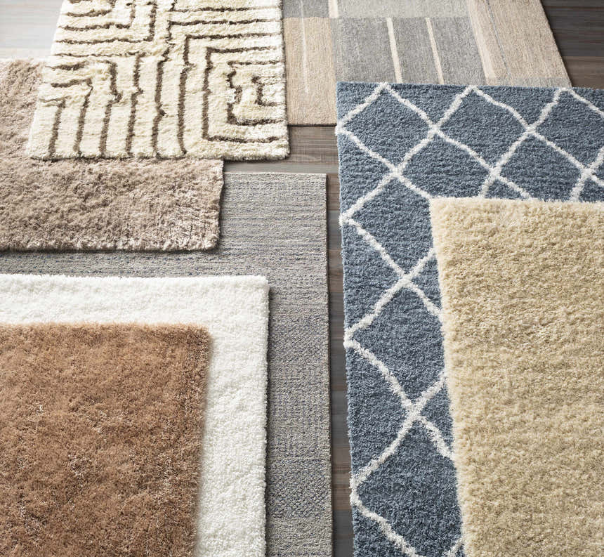 Close-up of multiple rugs, including Glouster Taupe&Gray Lined Area Rug. Various textures, colors, and patterns. Styleshot