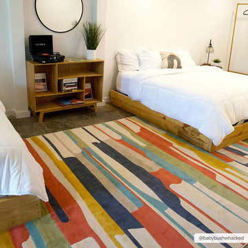 Bedroom scene with a colorful Southfields rug, wood bed frames, and mid-century modern decor. Roomscene-Rectangle