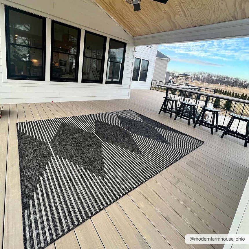 Modern farmhouse porch with black Stephan Area Rug, bar-height table and stools, and white siding. Roomscene-Rectangle