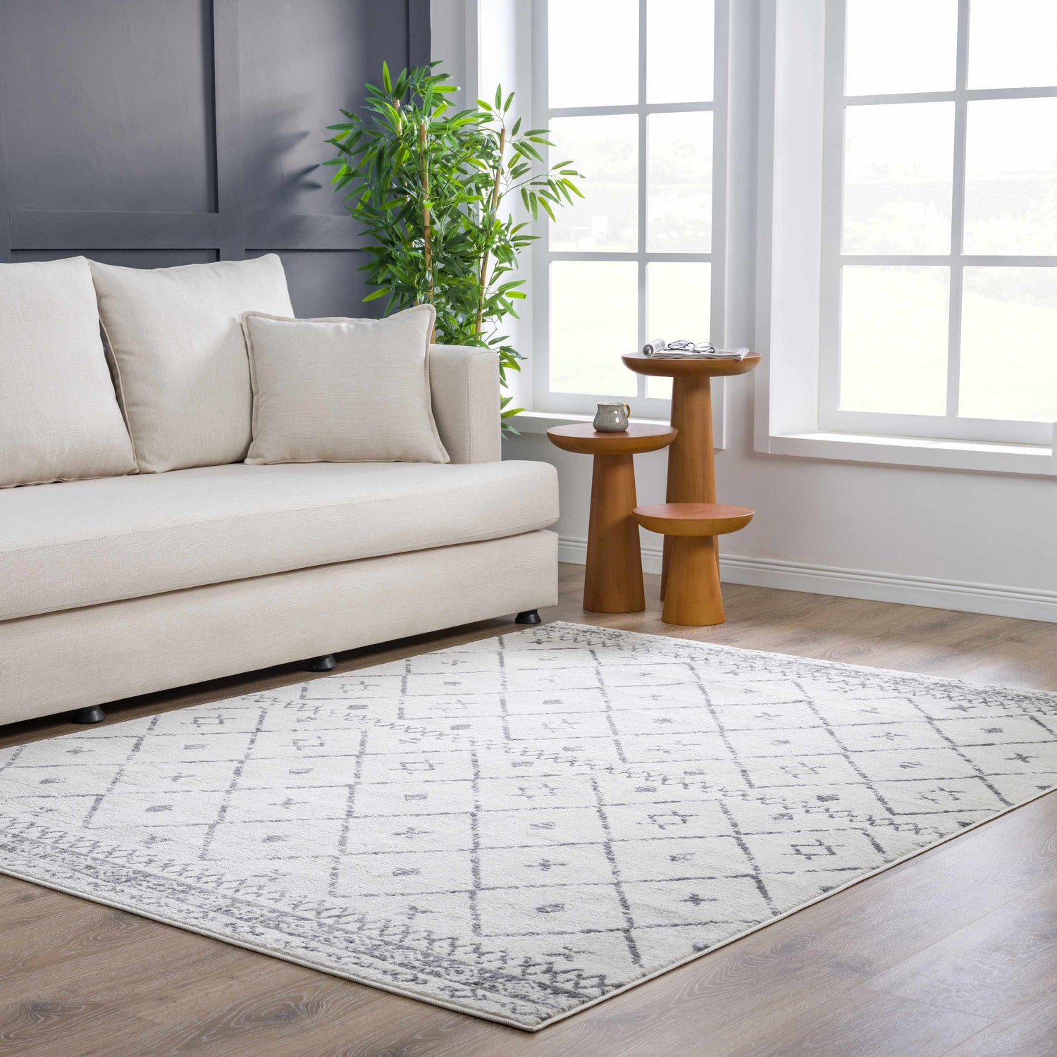Living room scene with a Tigris Area Rug, a beige sofa, and wooden side tables by a bright window. Roomscene-Rectangle