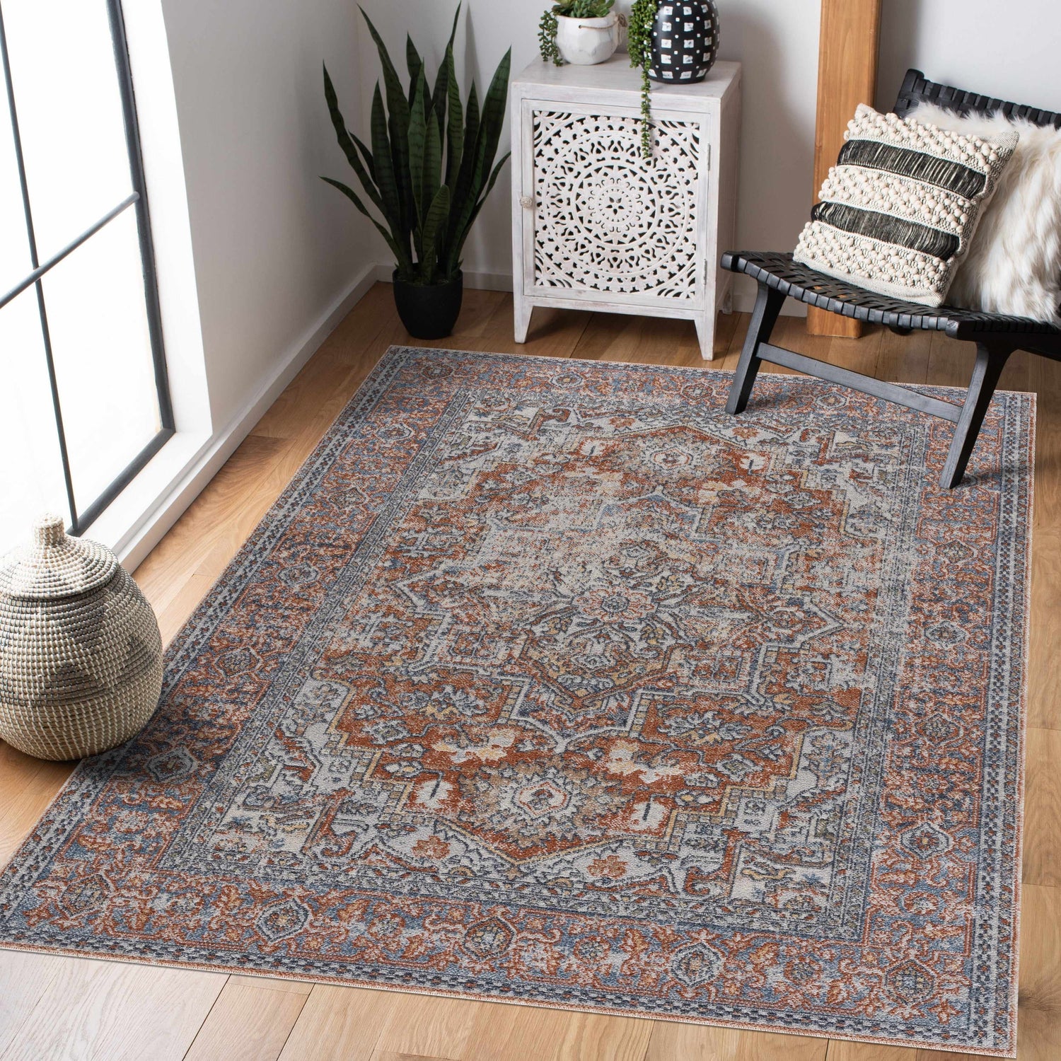 Entryway scene with Aila Traditional Design Washable Rug in blue, orange, and off-white. Vintage style with a black accent chair. Roomscene-Rectangle