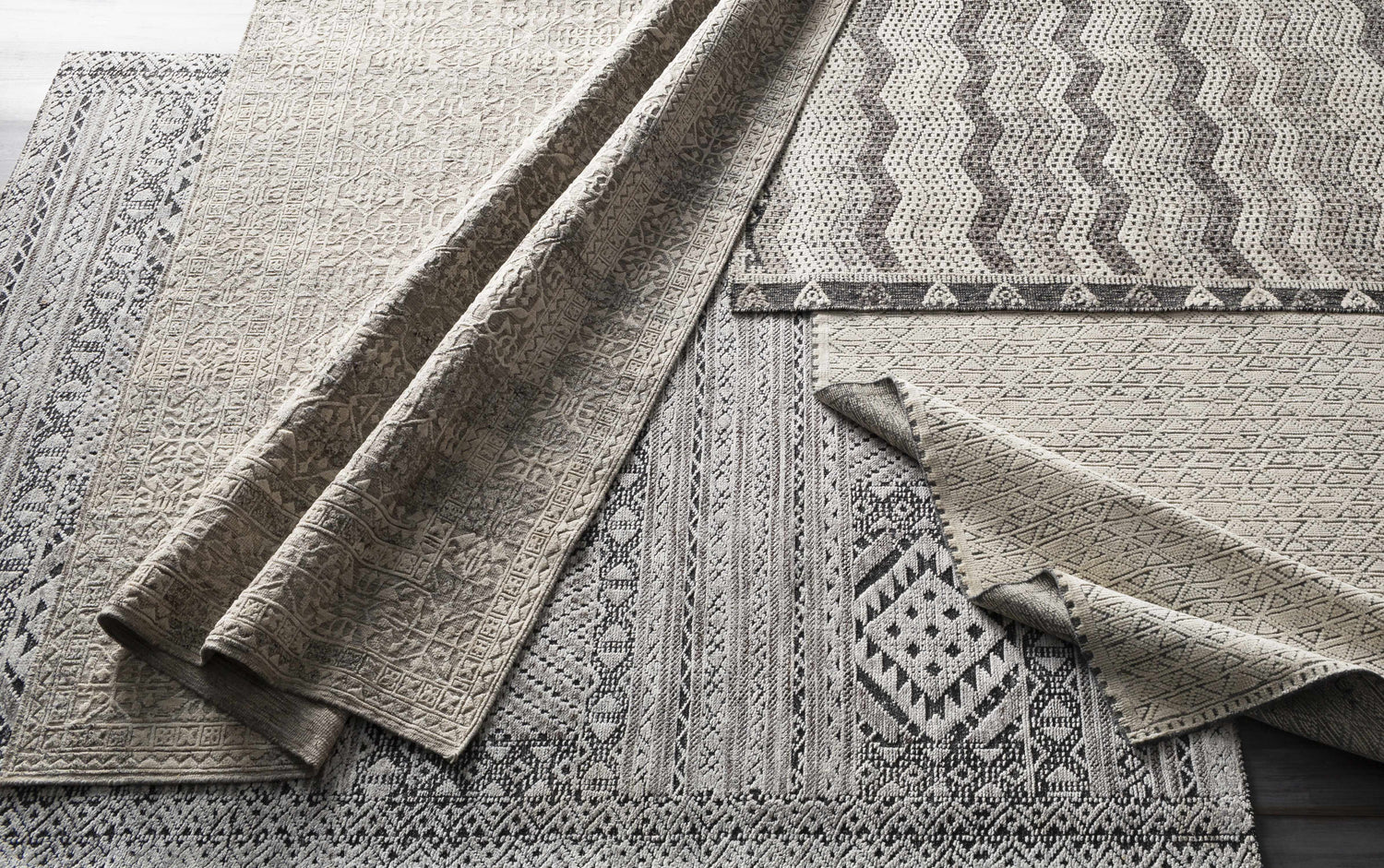 Close-up of Belspring Carpet featuring geometric patterns in black, dark brown, ivory, and gray. Hand-knotted 100% wool texture. Styleshot
