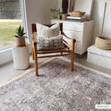 Neutral living room with Jill Washable Area Rug. Vintage rug with brown, blue, and cream tones under a leather chair. Roomscene-Rectangle