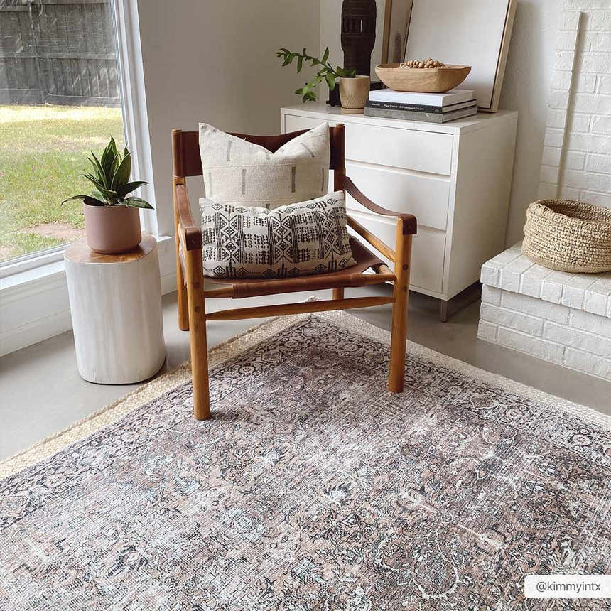 Neutral living room with Jill Washable Area Rug. Vintage rug with brown, blue, and cream tones under a leather chair. Roomscene-Rectangle