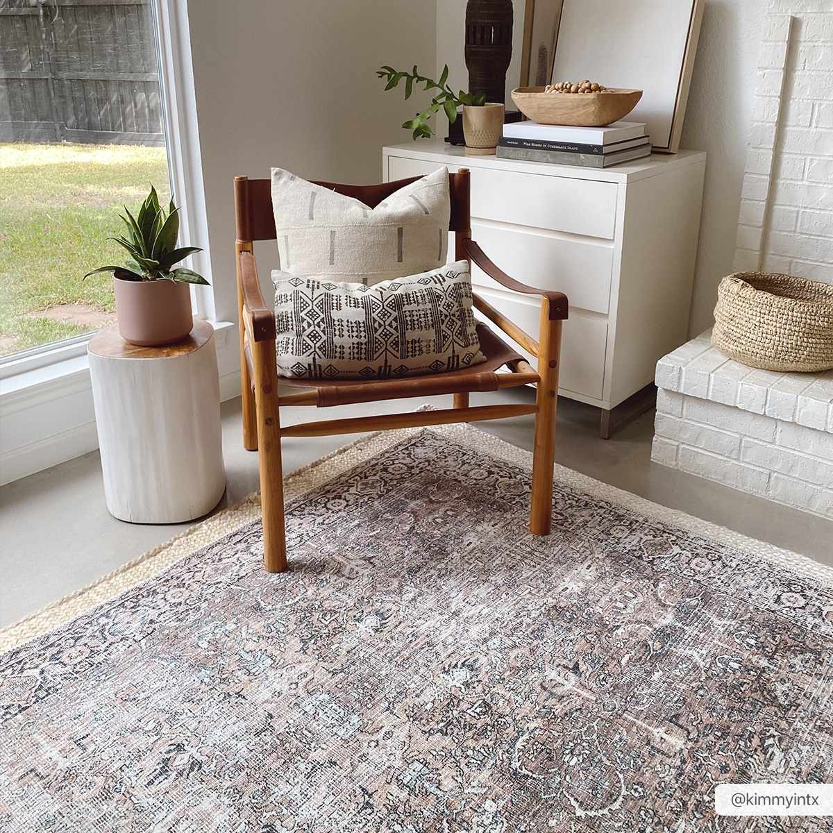 Neutral living room with Jill Washable Area Rug. Vintage rug with brown, blue, and cream tones under a leather chair. Roomscene-Rectangle