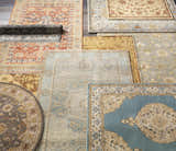Overhead shot of assorted Brookeland Area Rugs in beige, red, blue, sage, tan, and slate colors. Styleshot