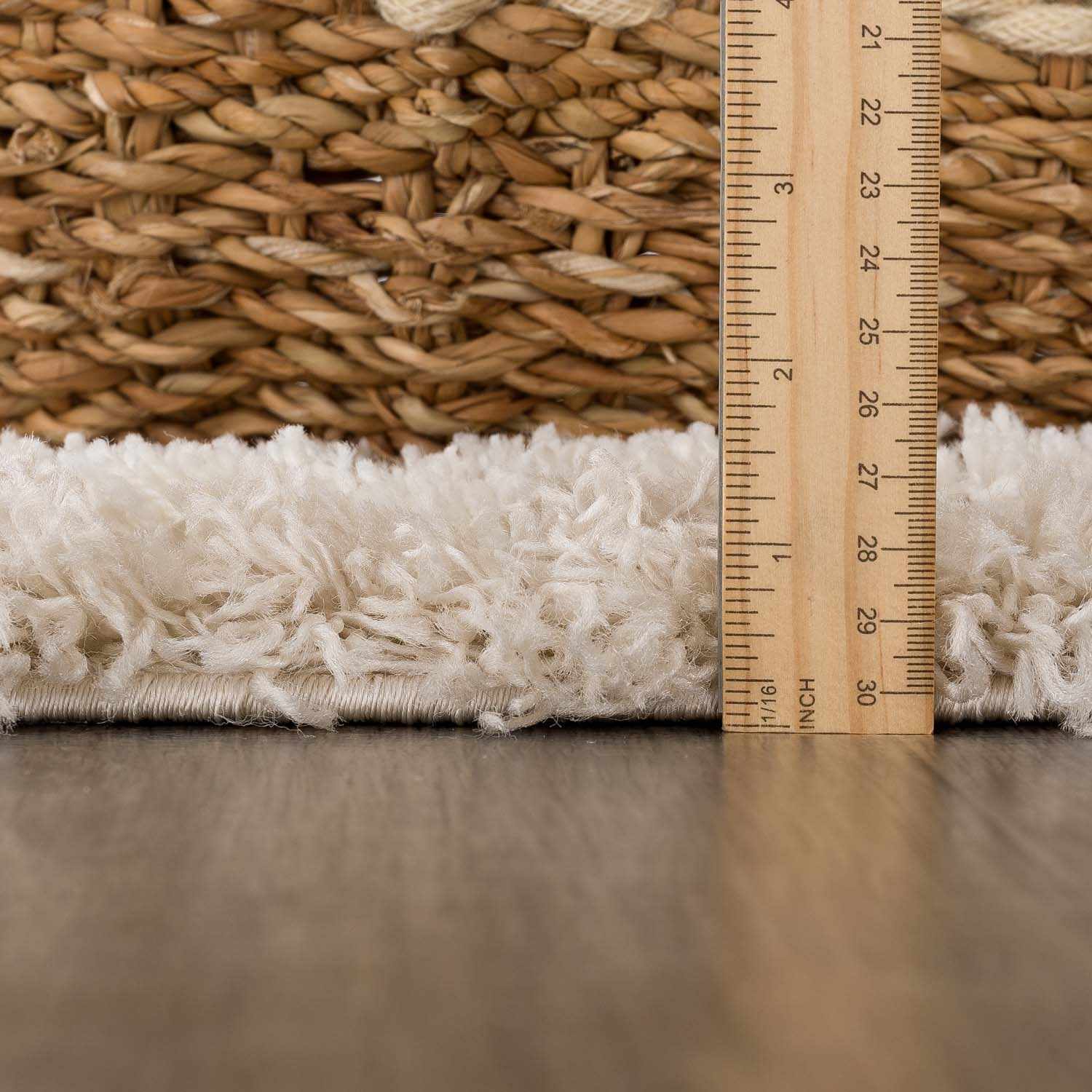 Close up of the Emmly Shag Area Rug showing the pile height with a ruler. Pile