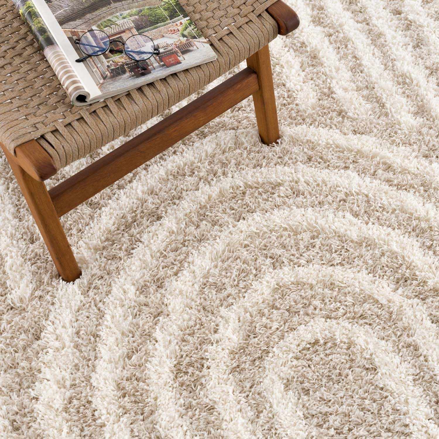 Close-up of the Emmly Shag Area Rug with a geometric pattern and plush texture, styled with a woven chair. Styleshot