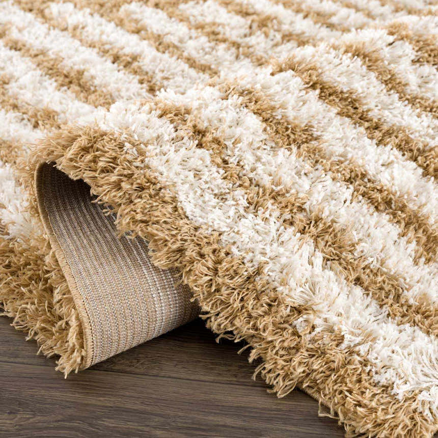 Close up of a Calup Shag Area Rug showing the bone and dark brown striped pattern and plush texture. Fold