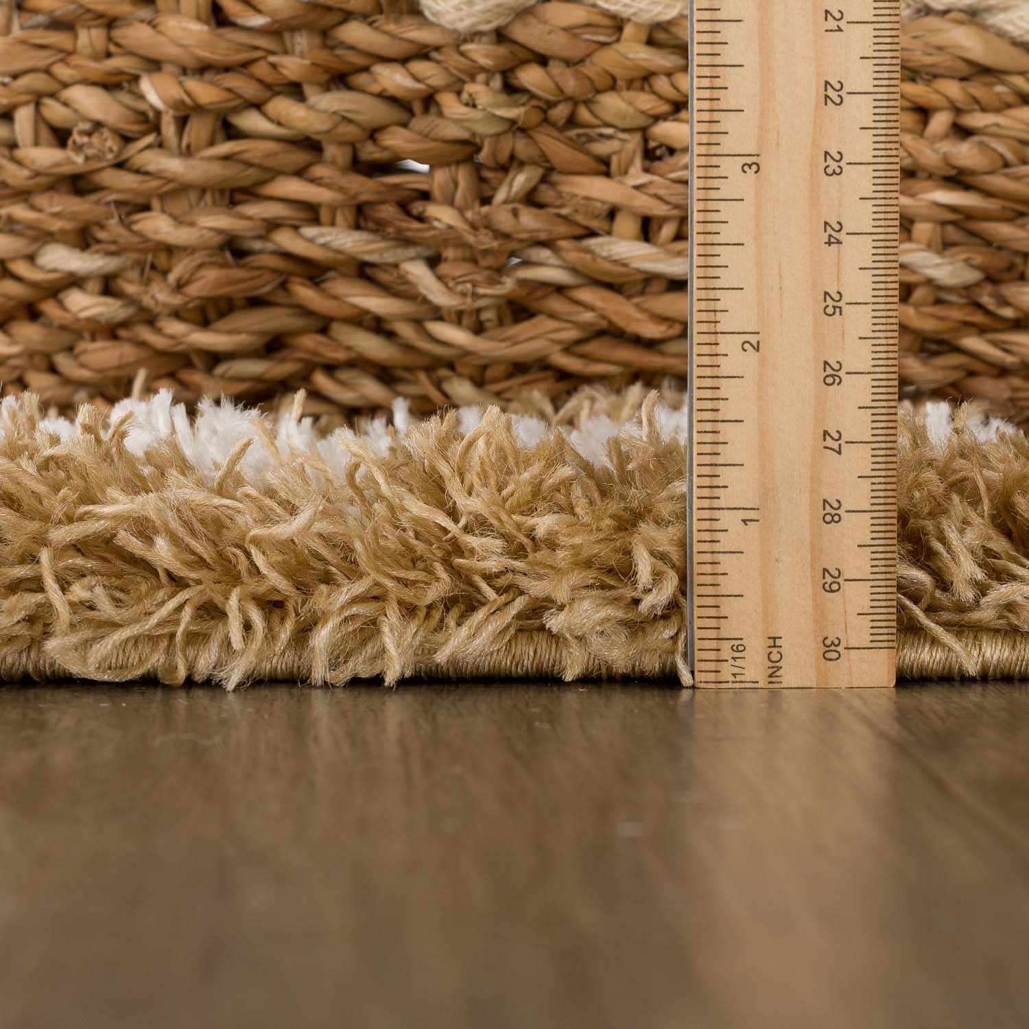 Close-up of the Calup Shag Area Rug pile height in bone and brown, showing the texture and thickness. Pile