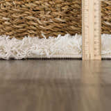 Close-up of the Atira Light Brown Checkered Area Rug showing the shag texture and pile height with a ruler. Pile