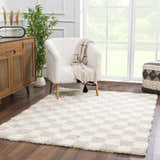 Living room scene with Atira Light Brown Checkered Area Rug, white chair, wood cabinet, and large window. Neutral tones. Roomscene-Rectangle