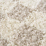 Close-up of the shaggy Atira Light Brown Checkered Area Rug, showing cream and light beige fibers. Texture