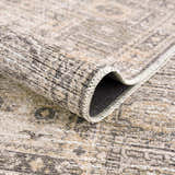 Close up of the Keola Washable Area Rug showing its texture, neutral colors, and traditional pattern. Fold