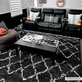 Living room scene with a Wallagrass Black Moroccan Shag Rug, black leather sofa, and Halloween decor. Roomscene-Rectangle