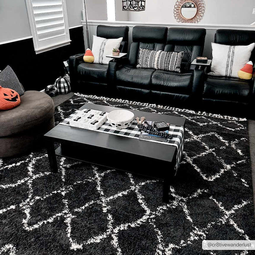 Living room scene with a Wallagrass Black Moroccan Shag Rug, black leather sofa, and Halloween decor. Roomscene-Rectangle