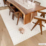 Dining room with wood table and Deron White Washable 3D Rug. A cute dog sits on the rug. Roomscene-Rectangle