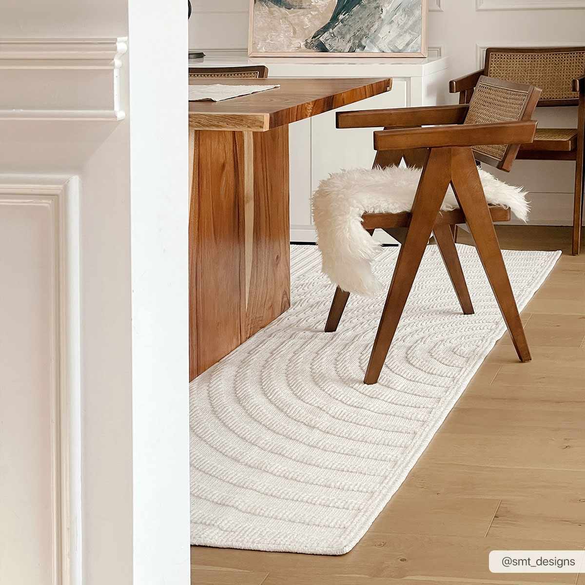 Dining room with a wood table and Deron White Washable 3D Rug in off-white with a subtle geometric pattern. Styleshot