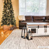 Living room scene with Christmas tree and cream, black Williford Wool Area Rug. Farmhouse style with brown leather couch. Roomscene-Rectangle